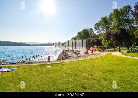 Touristen und einheimische Idahoans genießen einen Sommernachmittag am City Beach und Park entlang des Lake Coeur d'Alene, im Inland im Nordwesten der USA. Stockfoto