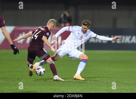 Riga, Lettland. November 2020. Rogvi Baldvinsson(R) der Färöer-Inseln steht mit dem lettischen Andrejs Ciganiks während ihres Fußballspiels der UEFA Nations League am 14. November 2020 in Riga, Lettland, auf dem Spiel. Kredit: Edijs Palens/Xinhua/Alamy Live Nachrichten Stockfoto