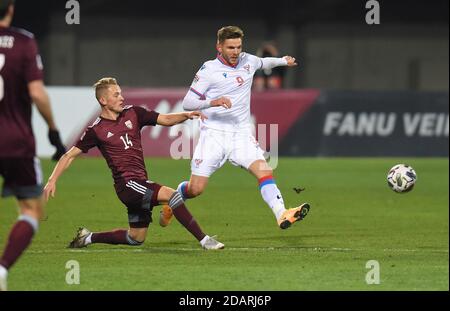 Riga, Lettland. November 2020. Rogvi Baldvinsson (R) der Färöer-Inseln steht mit dem lettischen Andrejs Ciganiks während ihres Fußballspiels der UEFA Nations League am 14. November 2020 in Riga, Lettland, im Spiel. Kredit: Edijs Palens/Xinhua/Alamy Live Nachrichten Stockfoto