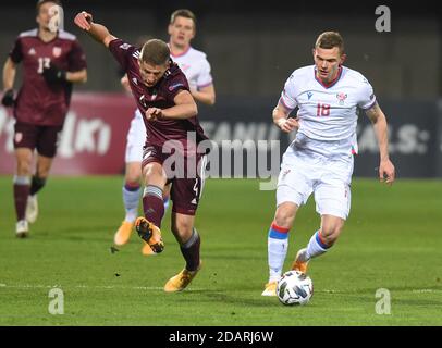 Riga, Lettland. November 2020. Meinhard Olsen (R) der Färöer-Inseln steht mit dem lettischen Kaspars Dubra während des Fußballspiels der UEFA Nations League am 14. November 2020 in Riga, Lettland, auf dem Spiel. Kredit: Edijs Palens/Xinhua/Alamy Live Nachrichten Stockfoto