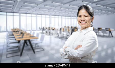Glücklich asiatische Arbeiter Arm gekreuzt im Büro Stockfoto