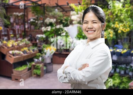 Asiatische weibliche Floristin oder Unternehmer mit Floristen Shop Hintergrund Stockfoto