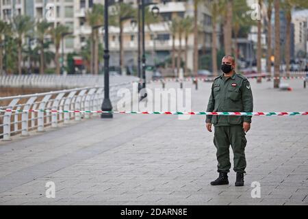 (201115) -- BEIRUT, 15. November 2020 (Xinhua) -- EIN Polizist steht Wache auf einer abgesperrten Straße am Meer, als das Land eine zweiwöchige Sperre einsetzte, um die Ausbreitung des Coronavirus in Beirut, Libanon, am 14. November 2020 zu begrenzen. Restaurants, Bars, Cafés, Fitnessstudios und Einkaufszentren schlossen am Samstag ihre Türen, als der Libanon seinen ersten Tag einer zweiwöchigen Sperre eintrat, um die Ausbreitung von COVID-19 einzuschränken. Fahrzeuge dürfen an bestimmten Tagen auf der Grundlage ihrer Plattennummern fahren. Allerdings waren die meisten Straßen in der Hauptstadt Beirut leer, berichtete der lokale Fernsehsender LBCI. (Xinhua/Bilal Jawich) Stockfoto