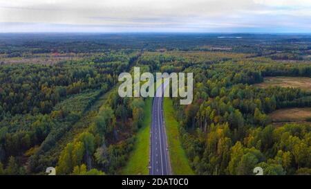 Teil der Autobahn im September. Entlang des Mischwaldes. Mit Blick in den Himmel. Draufsicht Stockfoto