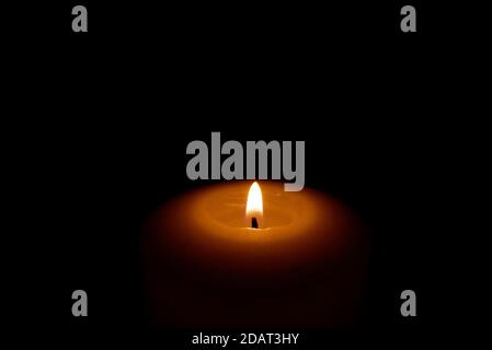 Nahaufnahme der Wachskerze auf dunkelschwarzem Hintergrund mit Kopierraum. Stockfoto