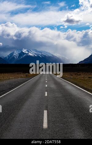 Gerade Straße führt voran in die Berge mit Regen Stockfoto