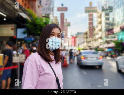 Junge Frau mit Maske in Yaowarat Straße zur Prävention COVID-19 Virus Pandemie in Bangkok Chinatown. Stockfoto