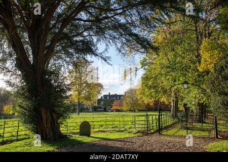 Cornwell Manor im Herbst. Cornwell, Chipping Norton, Oxfordshire, Cotswolds, England. Vom öffentlichen Fußweg durch den Kirchhof aus gesehen. Stockfoto