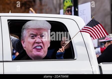 Carson, Usa. November 2020. Ein Lkw-Passagier hält während der Kundgebung eine trump-Maske und eine amerikanische Flagge aus.Pro Trump-Anhänger nehmen am "Millionen-MAGA-Marsch" in der Landeshauptstadt Teil. Sie protestierten gegen das, was sie als die Wahl ansehen, die durch Betrug gestohlen wurde. Kredit: SOPA Images Limited/Alamy Live Nachrichten Stockfoto