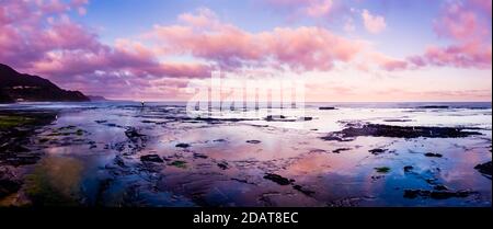 Sonnenuntergang Himmel und Fischer am Wombarra Strand Stockfoto