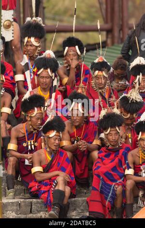 Naga Tribesmen tragen ihre traditionelle Kleidung und sitzen zusammen in Kisama Village Arena in Nagaland Indien am 4. Dezember 2016 Stockfoto