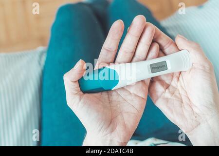 Frau mittleren Alters Hand hält Schwangerschaftstest, Ergebnis ist schwanger, "schwanger" Stockfoto