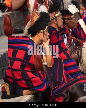 Naga Tribesmen tragen ihre traditionelle Kleidung und sitzen zusammen in Kisama Heritage Village Arena in Nagaland Indien am 4. Dezember 2016 Stockfoto