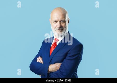 Lächelnder Geschäftsmann posiert mit gekreuzten Armen Stockfoto