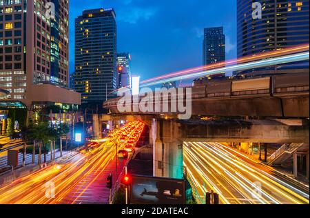 BANGKOK, THAILAND – 12. Oktober 2020: Stadtverkehr und Skytrain bei Nacht in Bangkok, Thailand Stockfoto