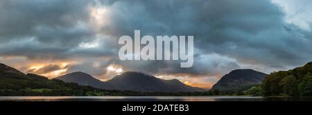 Atemberaubendes Landschaftsbild bei Sonnenaufgang mit Blick über Loweswater im See Bezirk in Richtung Low Fell und Grasmere mit bunten Himmel brechen Auf dem Berg Stockfoto
