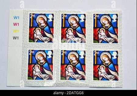 British Royal Mail zweite Klasse 65p Weihnachtsmarken für 2020 zeigen Jesus von Jungfrau Maria gekaschelt; Kopieren von Glasmalereien in anglikanischen Kirchen Stockfoto