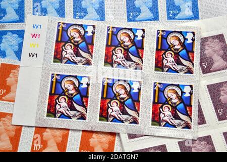 British Royal Mail zweite Klasse 65p Weihnachtsmarken für 2020 zeigen Jesus von Jungfrau Maria gekaschelt; Kopieren von Glasmalereien in anglikanischen Kirchen Stockfoto