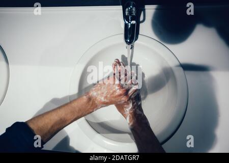 Nahaufnahme. Der Mensch wäscht sich vorsichtig die Hände mit Seife Stockfoto