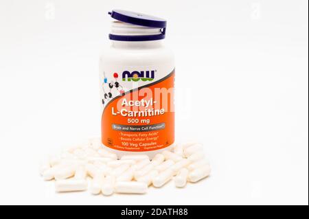 Jetzt Lebensmittel, Acetyl-L-Carnitin, 500 mg, 100 Veg Kapseln und mehrere vor der Flasche verstreut. Isoliert auf weißem Hintergrund. Speicherplatz kopieren. Stockfoto