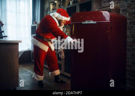 Böse freche Santa claus öffnet den Kühlschrank Stockfoto