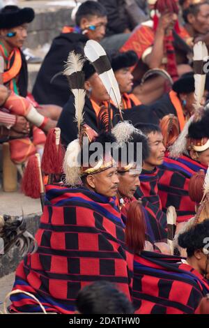 Naga Tribesmen tragen ihre traditionelle Kleidung und sitzen zusammen in Kisama Heritage Village Arena in Nagaland Indien am 4. Dezember 2016 Stockfoto