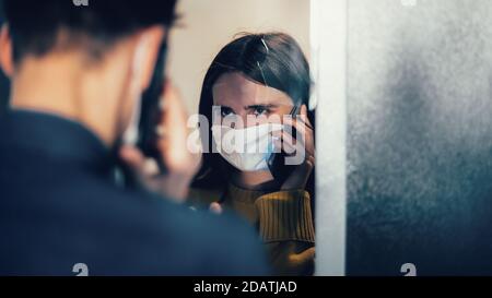 Nahaufnahme. Trauriges junges Paar in Schutzmasken, das sich anschaut. Stockfoto