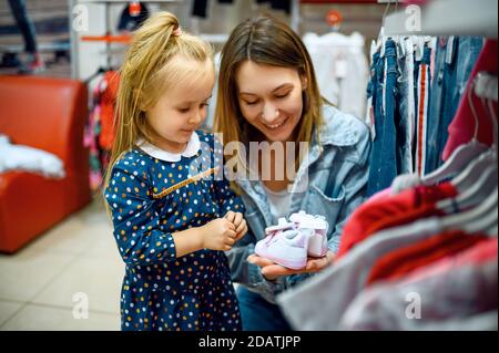 Mutter und kleines Baby kaufen Kleidung, Kindergeschäft Stockfoto