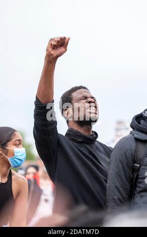 Ein Mann protestiert leidenschaftlich, indem er seine Faust auf einen marsch der Schwarzen Leben im Hyde Park hebt. Stockfoto