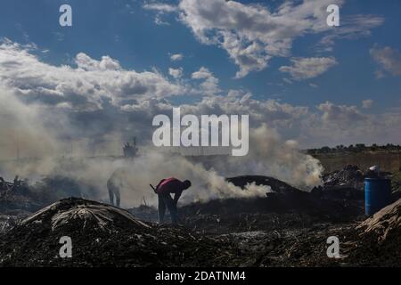 15. November 2020, Gaza-Stadt, Gaza-Streifen, Palästina: Ein palästinensischer Kohlearbeiter wirft Sand in die Al-Hattab-Produktionsanlage östlich des Flüchtlingslagers Jabalia, nördlich von Gaza-Stadt, Gazastreifen, 15. November 2020. Die Habash-Kohleanlage ist der größte Produzent im Gazastreifen. Sieben Männer arbeiten das ganze Jahr über, vor allem im Winter und in den Ferien, wenn Kohle gefragt ist. Während Arbeiter verschiedene Arten von Bäumen abhauen, wird Brennholz häufig verwendet, um Holzkohle zu machen. Der Zitrusbaum ist sehr vorteilhaft und die teuerste, aber habash Arbeiter nicht nur darauf konzentrieren und sich mit der Stockfoto