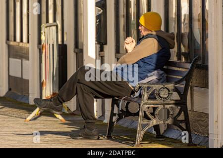 Ein älterer Herr, der alleine sitzt. Stockfoto