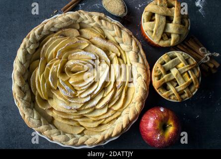 Verschiedene Gebäckstücke mit Äpfeln. Draufsicht Foto von süßen Kuchen auf grauem Hintergrund. Ideen für Weihnachtsmenüs. Stockfoto