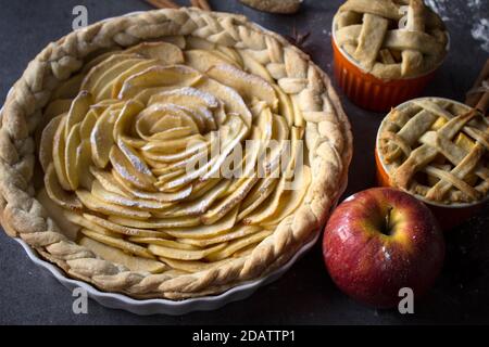 Apfelkuchen. Desserttörtchen auf einem Tisch. Foto von oben mit verschiedenen Apfelkuchen, Kuchen und Torten, frischen Pflaumen, Äpfeln und Kürbissen. Herbstmenü-Ideen. Stockfoto
