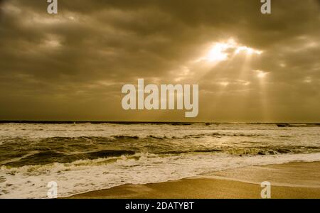 Sonnenschein über dem Meer durch die Wolken Blick aus Strand von somnath Tempel Gujarat Indien Stockfoto