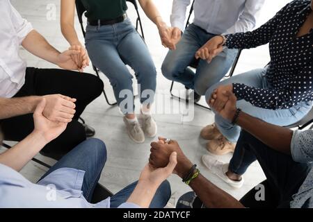 Verschiedene Menschen Gruppe sitzt auf Stühlen im Kreis vereint Hände Stockfoto