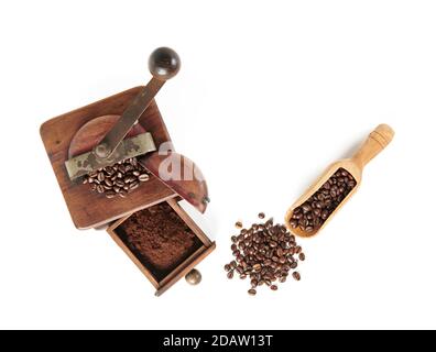 Kaffeebohnen mit Kaffeemühle aus Holz und Holzlöffel, von oben auf weißem Hintergrund, mit Schatten. Stockfoto