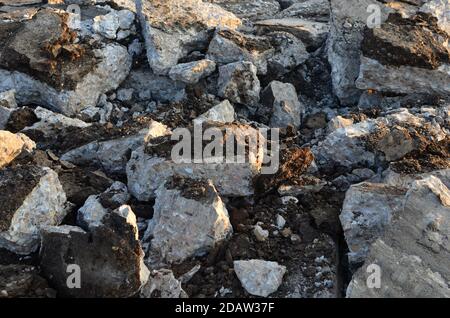 Zerbrochene Asphaltstücke auf einer Baustelle. Recycling und Wiederverwendung zerkleinerten Betonschutt, Asphalt, Baumaterial, Blöcke. Zerkleinert сoncrete Bac Stockfoto