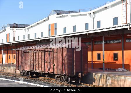 Be- und Entladen von Eisenbahnwaggons, Boxautos und Containern in temporären Lagerhallen. Zolllager mit Rampe. Zufahrtsbahn (Bahn d Stockfoto