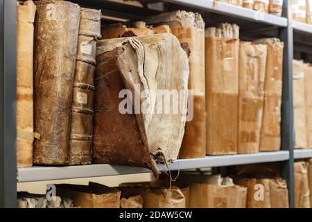 Alte abgenutzte Bücher aus dem 17. Jahrhundert auf einem Regal in der Regale der Bibliothek Stockfoto