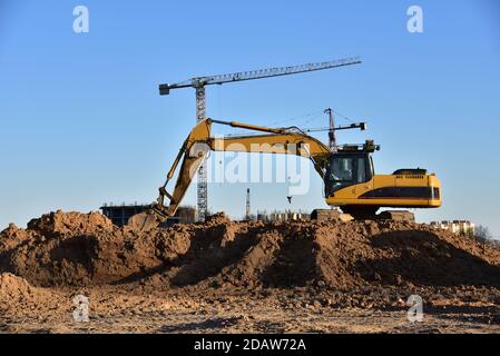 Bagger arbeiten auf der Baustelle. Bagger während Erdarbeiten. Graben Boden für das Fundament und für die Verlegung von Kanalrohren Fernwärme. Eart Stockfoto