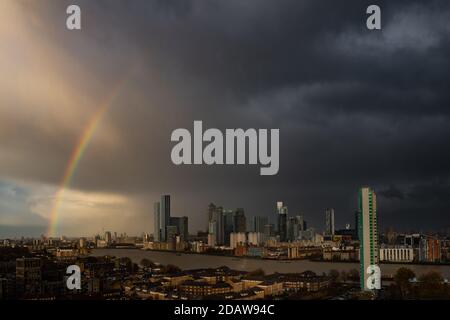 London, Großbritannien. November 2020. UK Wetter: Ein massiver Regenbogen beginnt sich über Ost-London und Canary Wharf Gebäude zu ziehen, als ein kurzer Nachmittag Regensturm aufklärt. Kredit: Guy Corbishley/Alamy Live Nachrichten Stockfoto