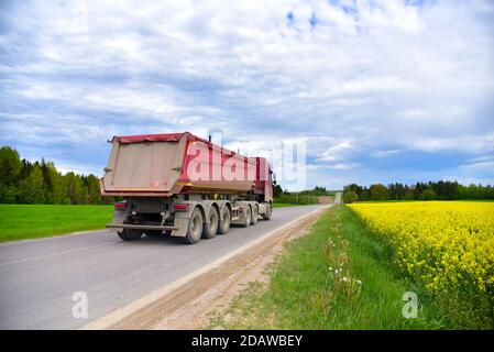 LKW mit Kipper Sattelauflieger transportierte Sand aus dem Steinbruch auf der Fahrt entlang der Autobahn. Moderne Dump Semi-Trailer Heckkipper Lkw-Anhänger Stockfoto