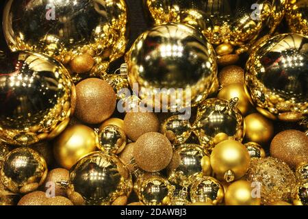 goldene Kugeln mit Funkeln und Reflexen, Hintergrund mit Dekorelementen für Design im Disco-Stil zu Weihnachten und Neujahr Stockfoto