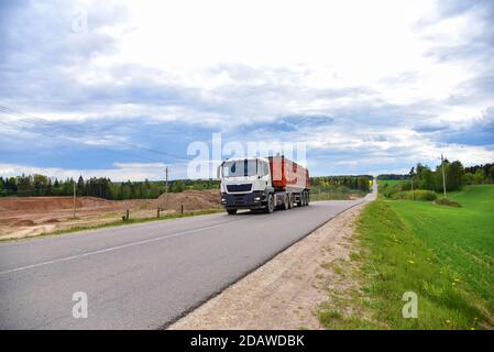 LKW mit Kipper Sattelauflieger transportierte Sand aus dem Steinbruch auf der Fahrt entlang der Autobahn. Stockfoto