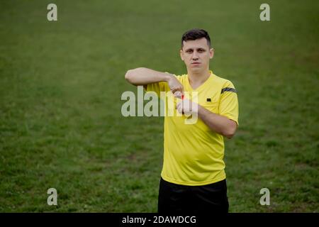 Fußballschiedsrichter, um eine gelbe Karte zu zeigen Spieler im Fußballstadion Stockfoto