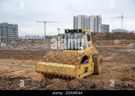 Bodenkompktor auf der Baustelle. Vibration Einzylinder-Straßenwalze zum Nivellieren von Boden, Kies, Beton oder Asphalt beim Straßenbau Stockfoto