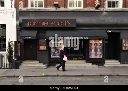 Eine Frau geht am Ronnie Scott's Jazz Club in Soho, London vorbei, der während der zweiten nationalen Sperre in England geschlossen wurde. Stockfoto