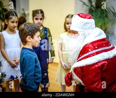 Sankt Petersburg, Russland - 23. Dezember 2016: Kinder-Neujahrsgrüße. Kinder spielen mit dem Schnee Maiden und Santa Claus. Emotionen hell Stockfoto