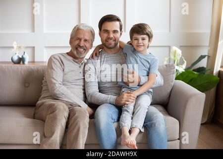 Familienportrait glücklich drei Generationen von Männern sitzen auf der Couch Stockfoto