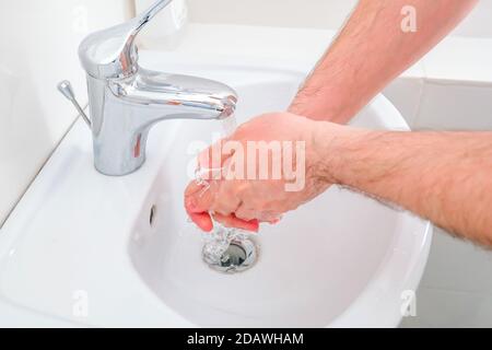 Der Mann wäscht sich die Hände. Waschbecken im Bestrahlungsraum. Stockfoto